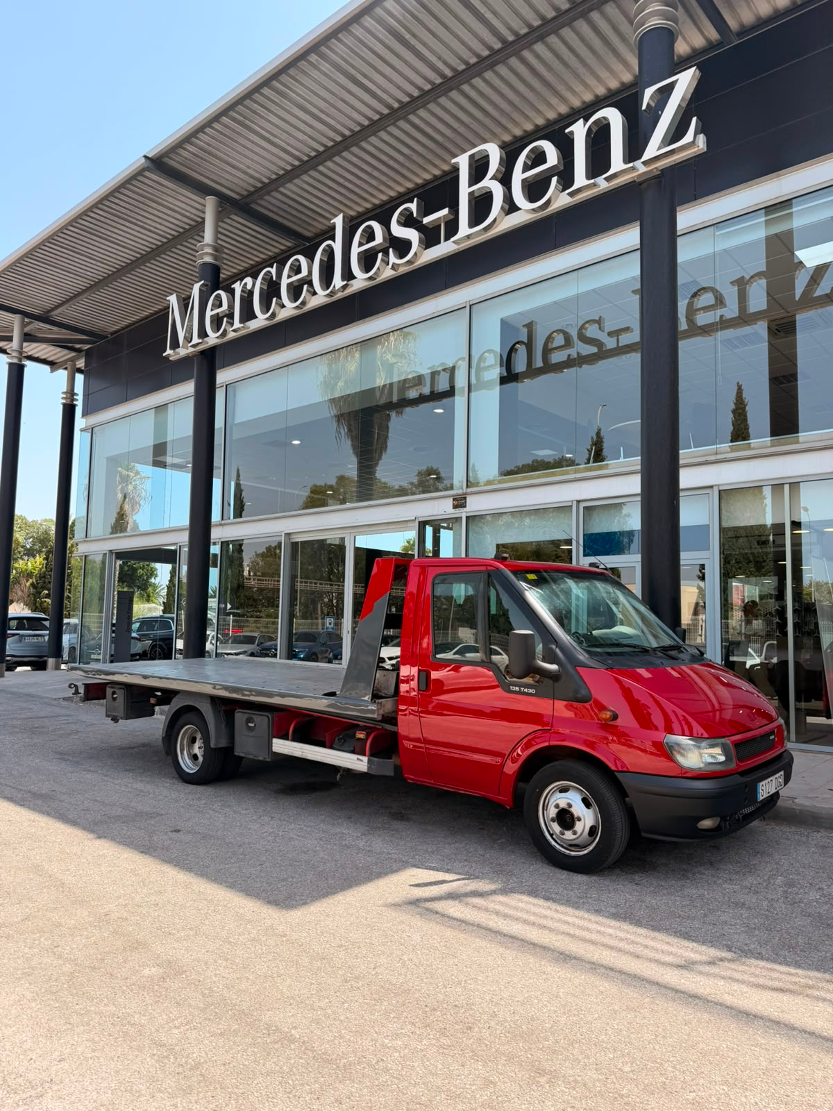 Grúa roja de Grúas Villalba frente a Mercedes-Benz